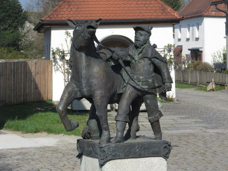 Am Prachatitzer Weg in Schiefweg steht diese Skulptur eines Säumers mit Pferd am Platz vor der kleinen Kirche
